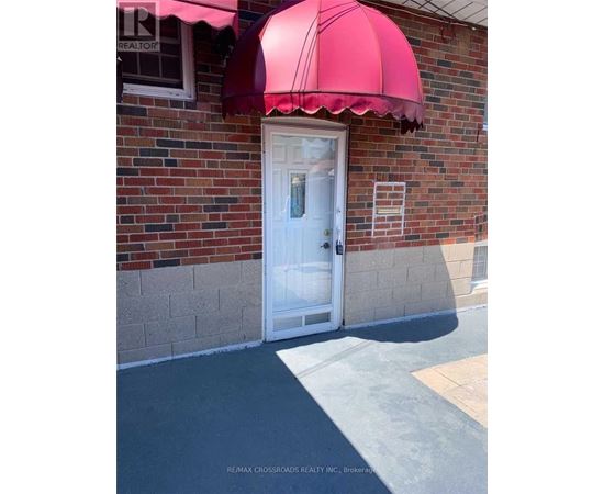 A white door is under a red awning.