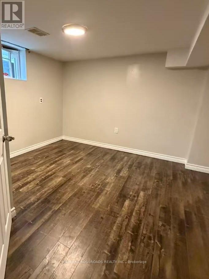 A room with wooden flooring and white walls.