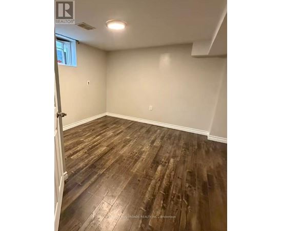 A room with wooden flooring and white walls.