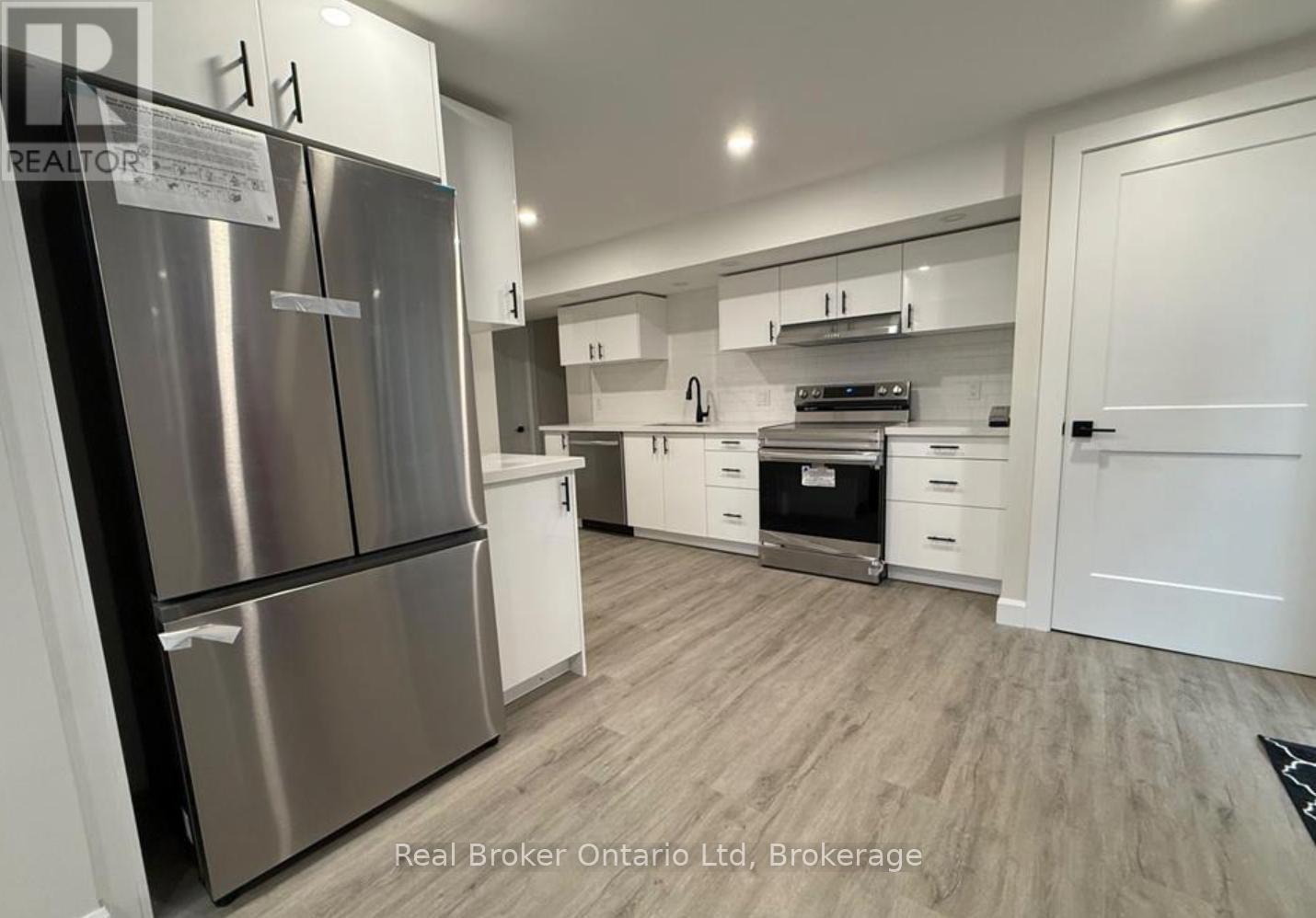 A modern kitchen with stainless steel appliances and white cabinetry.