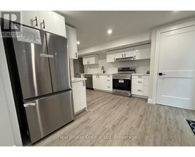 A modern kitchen with stainless steel appliances and white cabinetry.