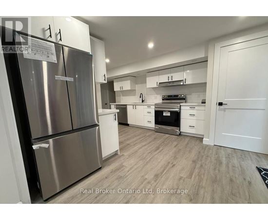 A modern kitchen with stainless steel appliances and white cabinetry.
