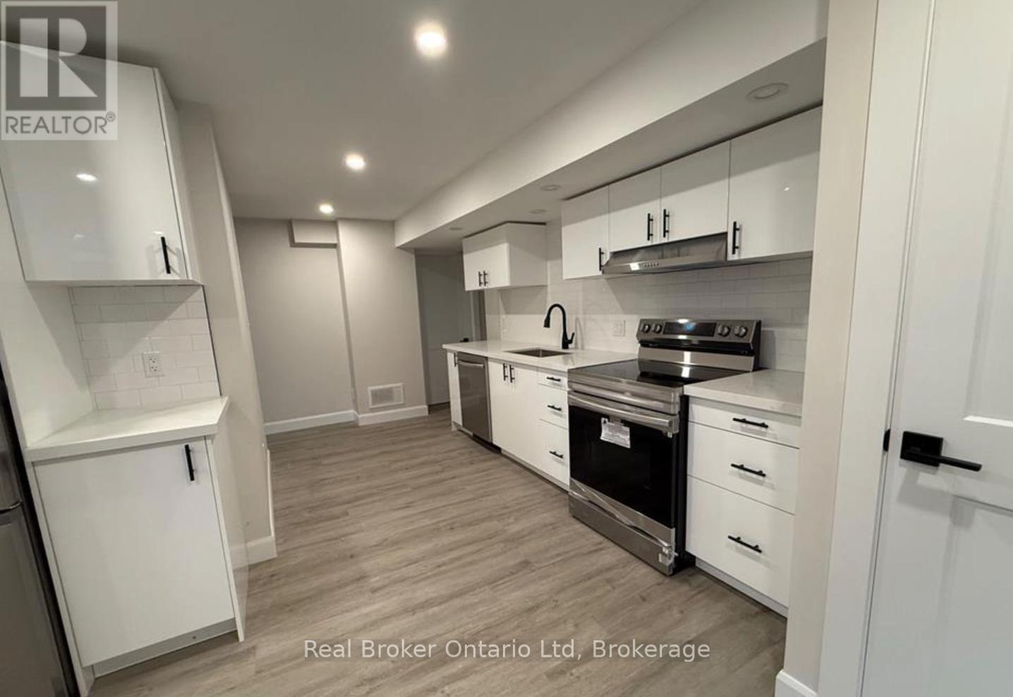 A modern kitchen with white cabinets and stainless steel appliances.
