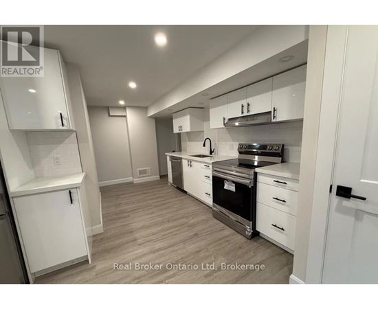 A modern kitchen with white cabinets and stainless steel appliances.