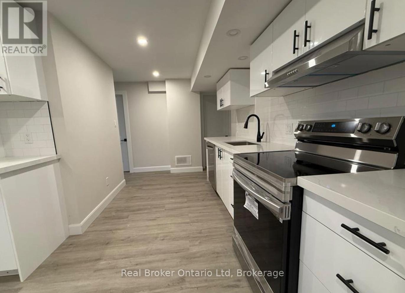 A kitchen with white cabinets and a stainless steel oven.
