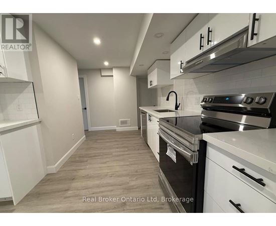 A kitchen with white cabinets and a stainless steel oven.