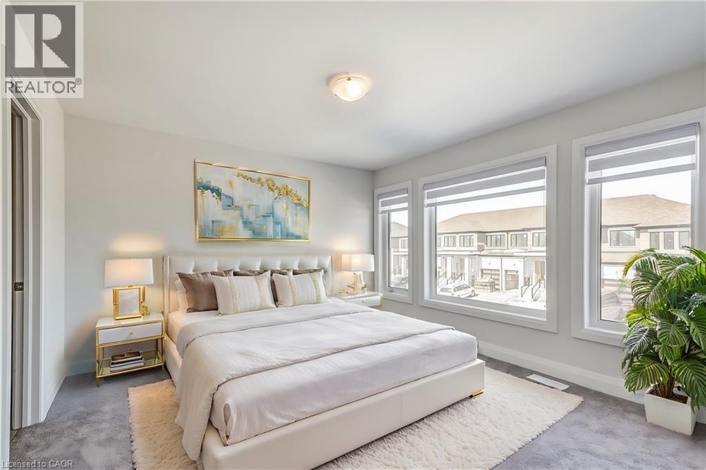 A bedroom with a large bed, a nightstand with a lamp, and a painting on the wall.