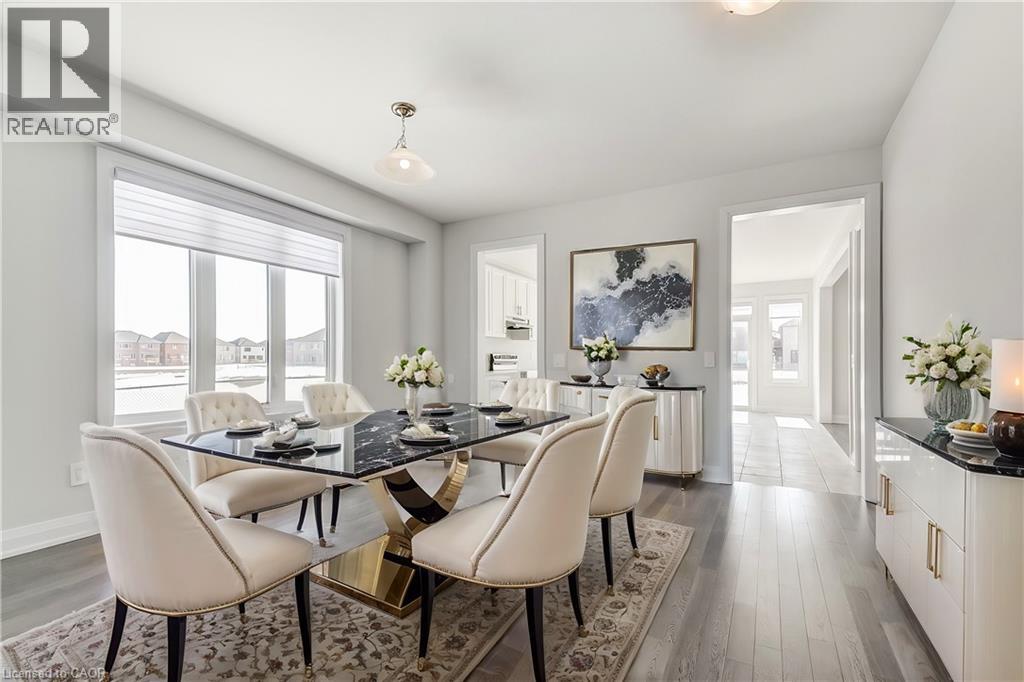 A dining room with a glass table and white chairs.