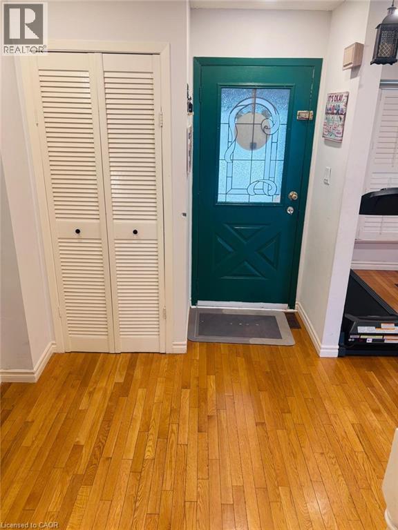 A green door with a glass window is in the middle of a room.