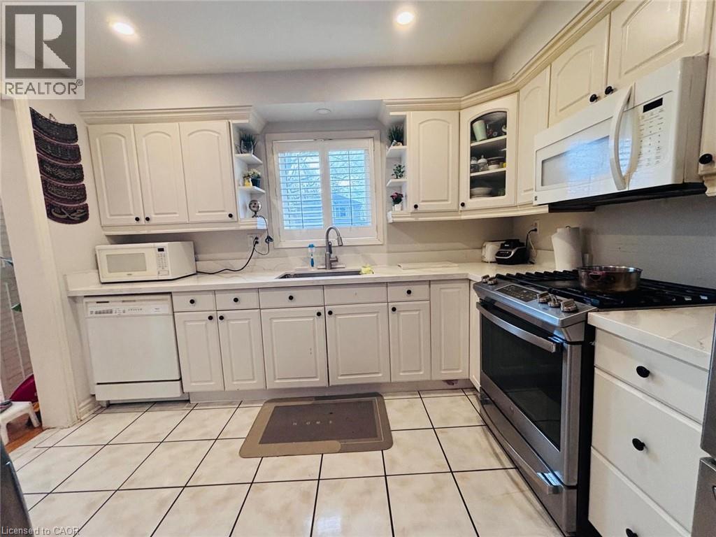 A white kitchen with a black stove top oven.