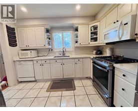 A white kitchen with a black stove top oven.