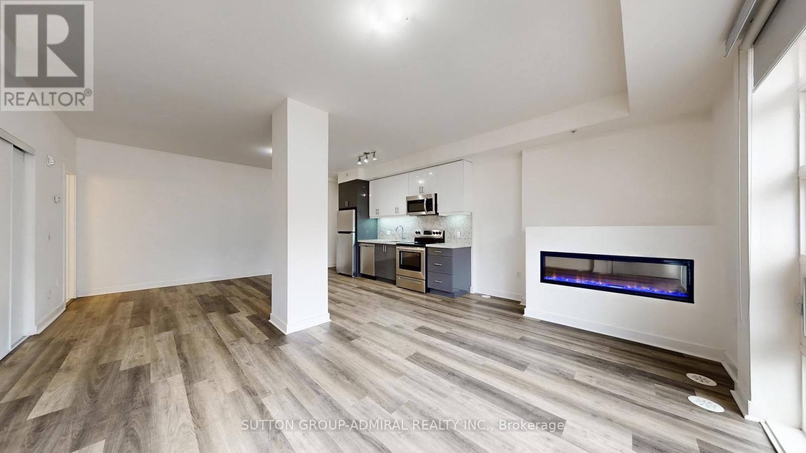 A spacious living room with a fireplace and a television.