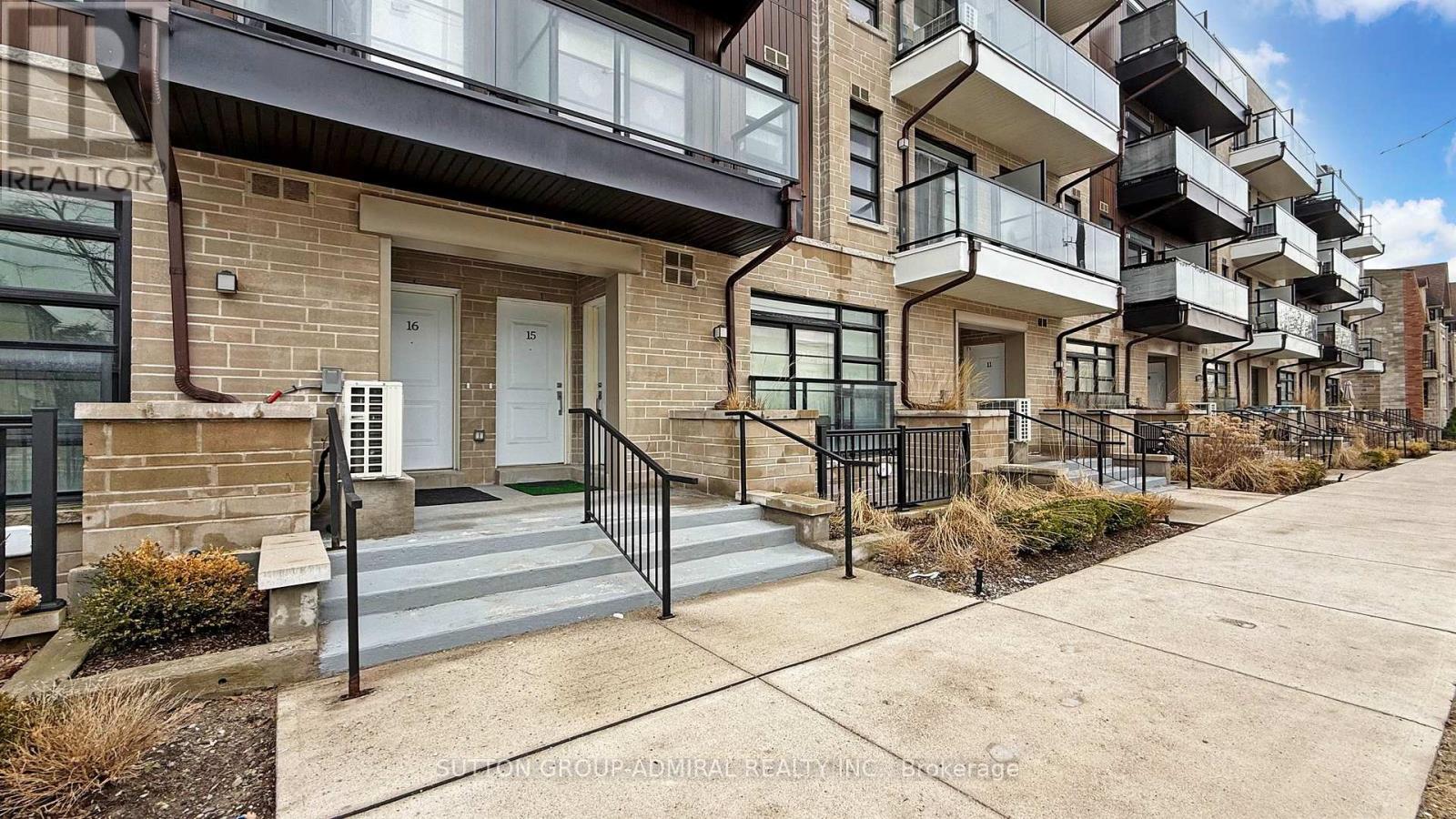 A row of modern townhouses with balconies and black railings.
