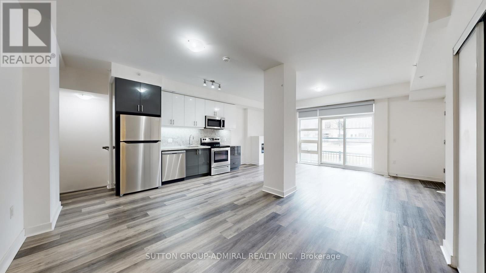 A spacious kitchen with a refrigerator, oven, and sink.