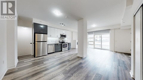 A spacious kitchen with a refrigerator, oven, and sink.