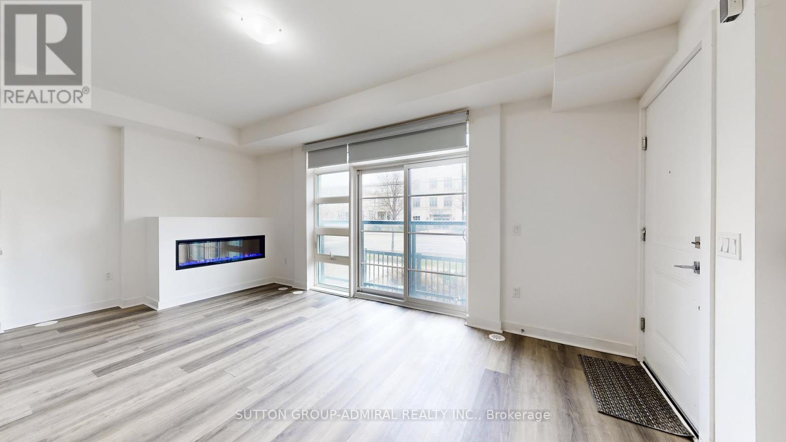 A spacious room with a large window and sliding glass doors.