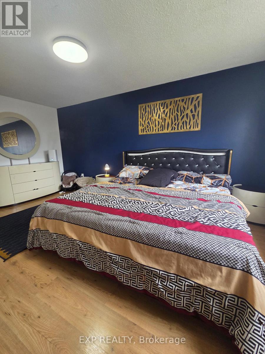 A bedroom with a bed, nightstand, and a wall hanging.