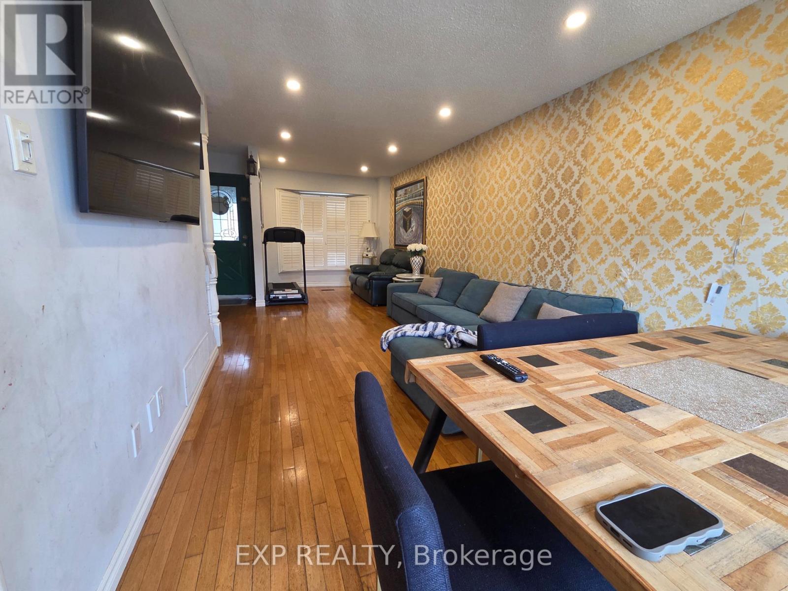 A living room with a couch, a coffee table, and a television.