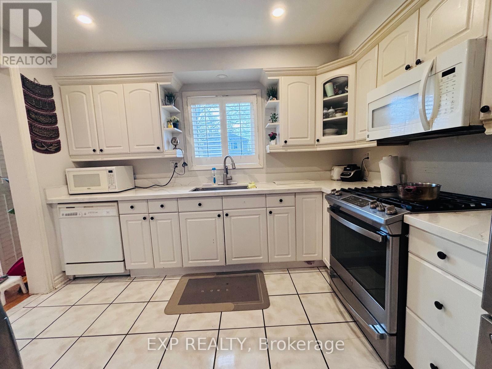 A kitchen with white cabinets and appliances.