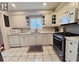 A kitchen with white cabinets and appliances.