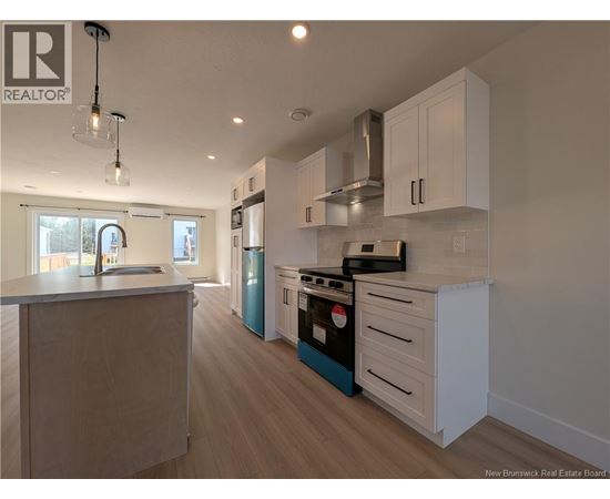 A kitchen with white cabinets and a blue dishwasher.