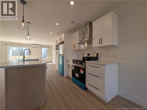A kitchen with white cabinets and a blue dishwasher.
