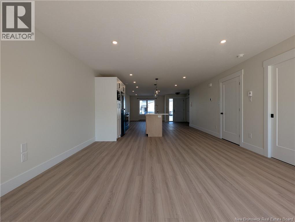 A spacious room with wooden flooring and white walls.