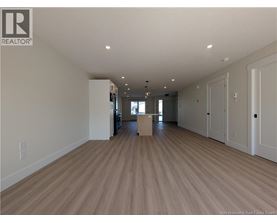 A spacious room with wooden flooring and white walls.