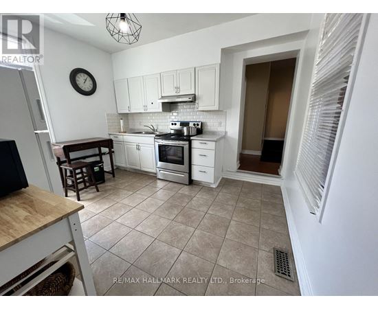 A kitchen with white cabinets and a tile floor.