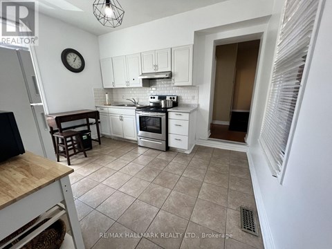 A kitchen with white cabinets and a tile floor.