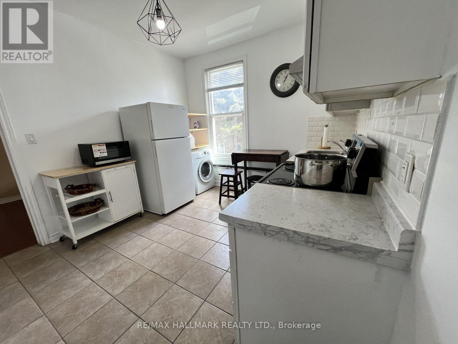 A kitchen with a marble countertop and a tile floor.