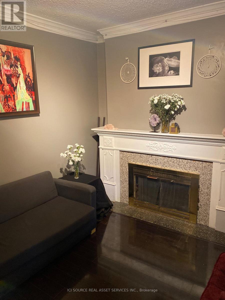 A grey couch sits in front of a fireplace in a living room.