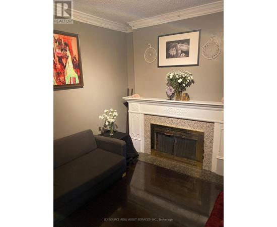 A grey couch sits in front of a fireplace in a living room.