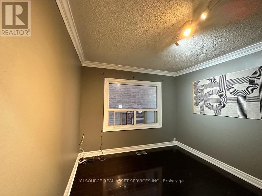 A room with a window and a painting on the wall.