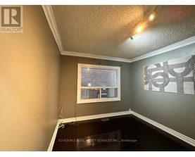 A room with a window and a painting on the wall.