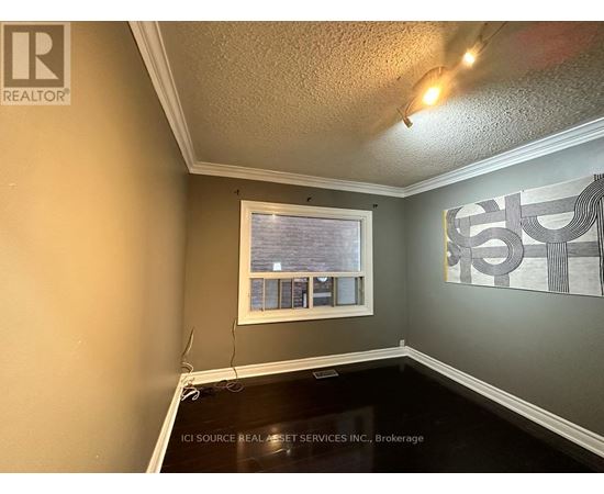 A room with a window and a painting on the wall.