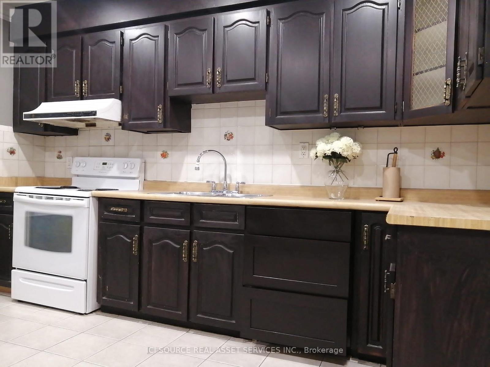A kitchen with dark brown cabinets and a white oven.