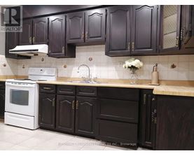 A kitchen with dark brown cabinets and a white oven.