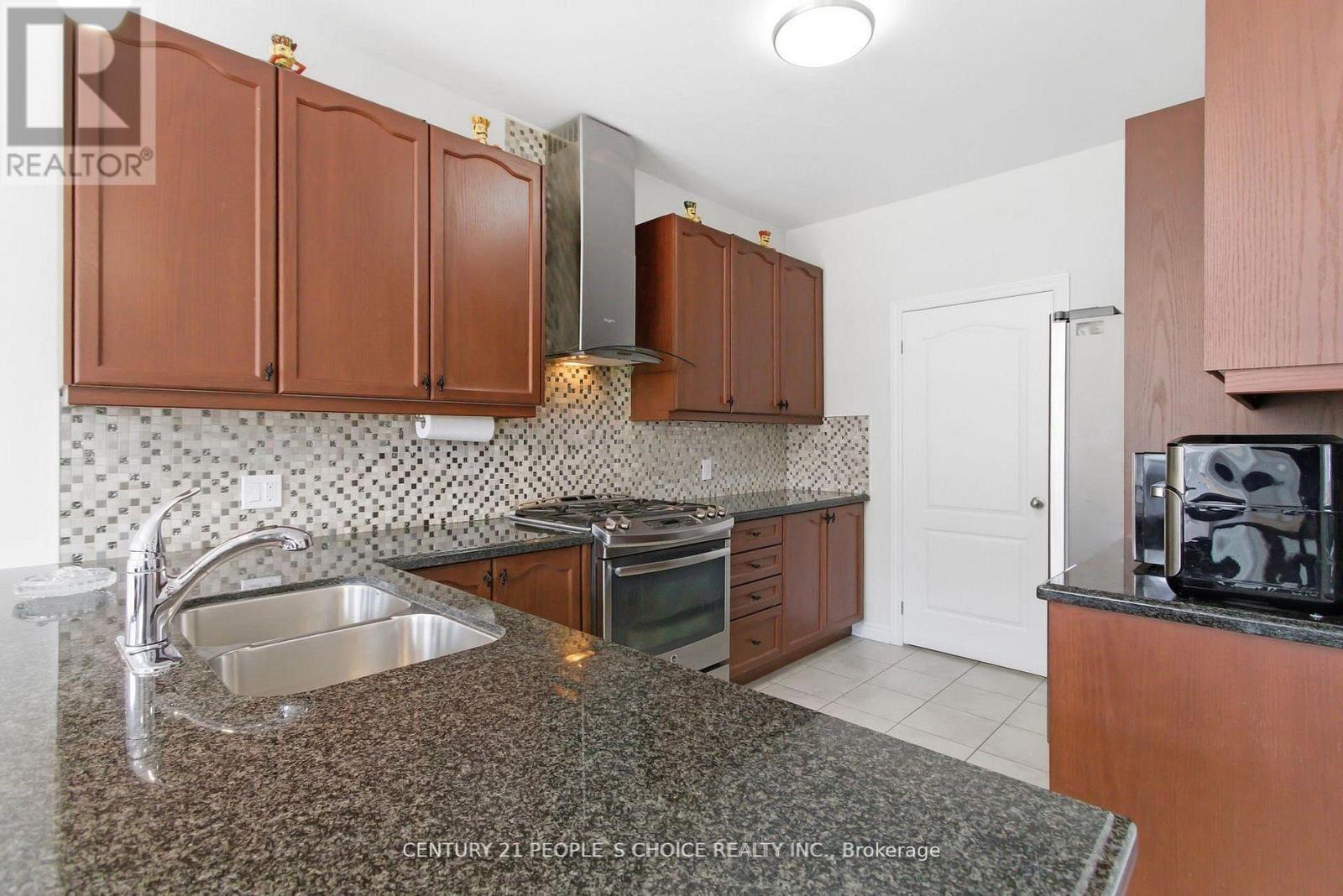 A kitchen with brown cabinets and a granite countertop.