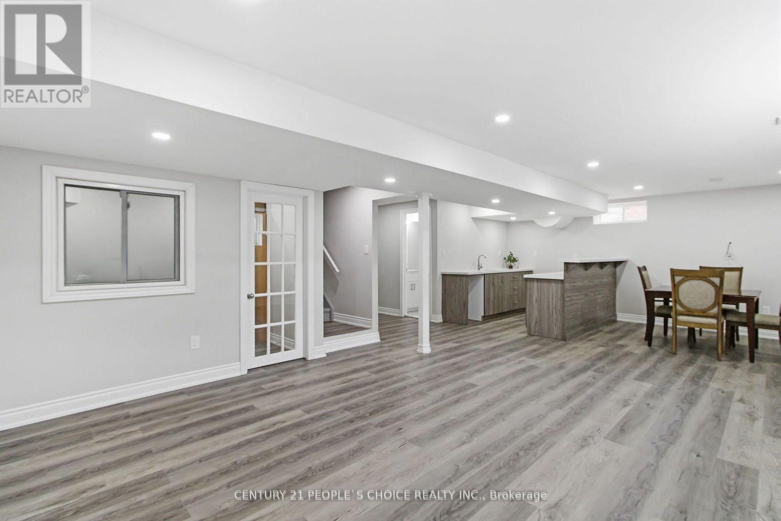 A spacious room with a dining table and chairs.