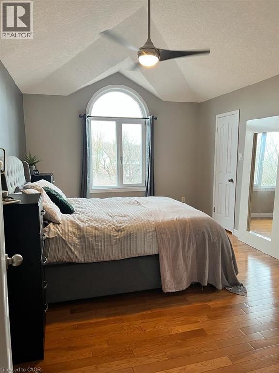 A bedroom with a bed, dresser, and window.