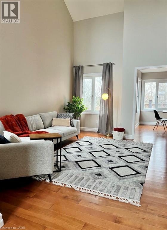 A living room with a grey couch and a rug.