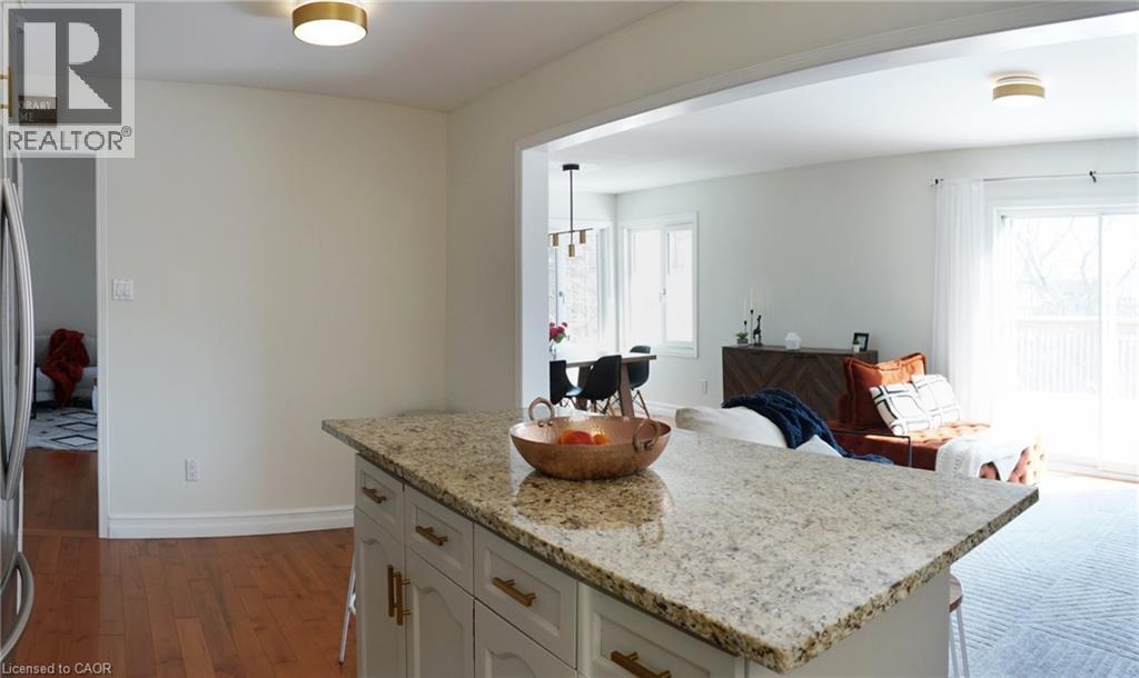 A kitchen with a granite countertop and a dining area with a table and chairs.