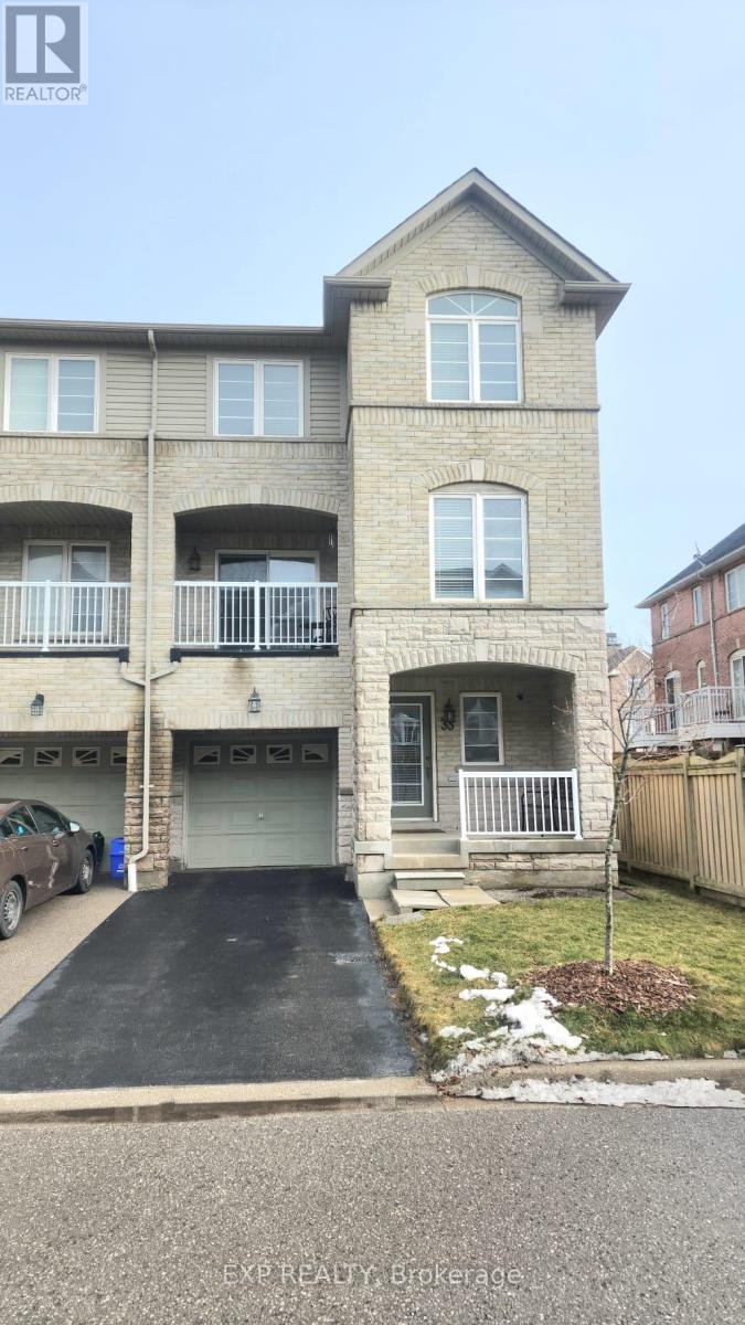 A two-story brick apartment building with a garage and a driveway.