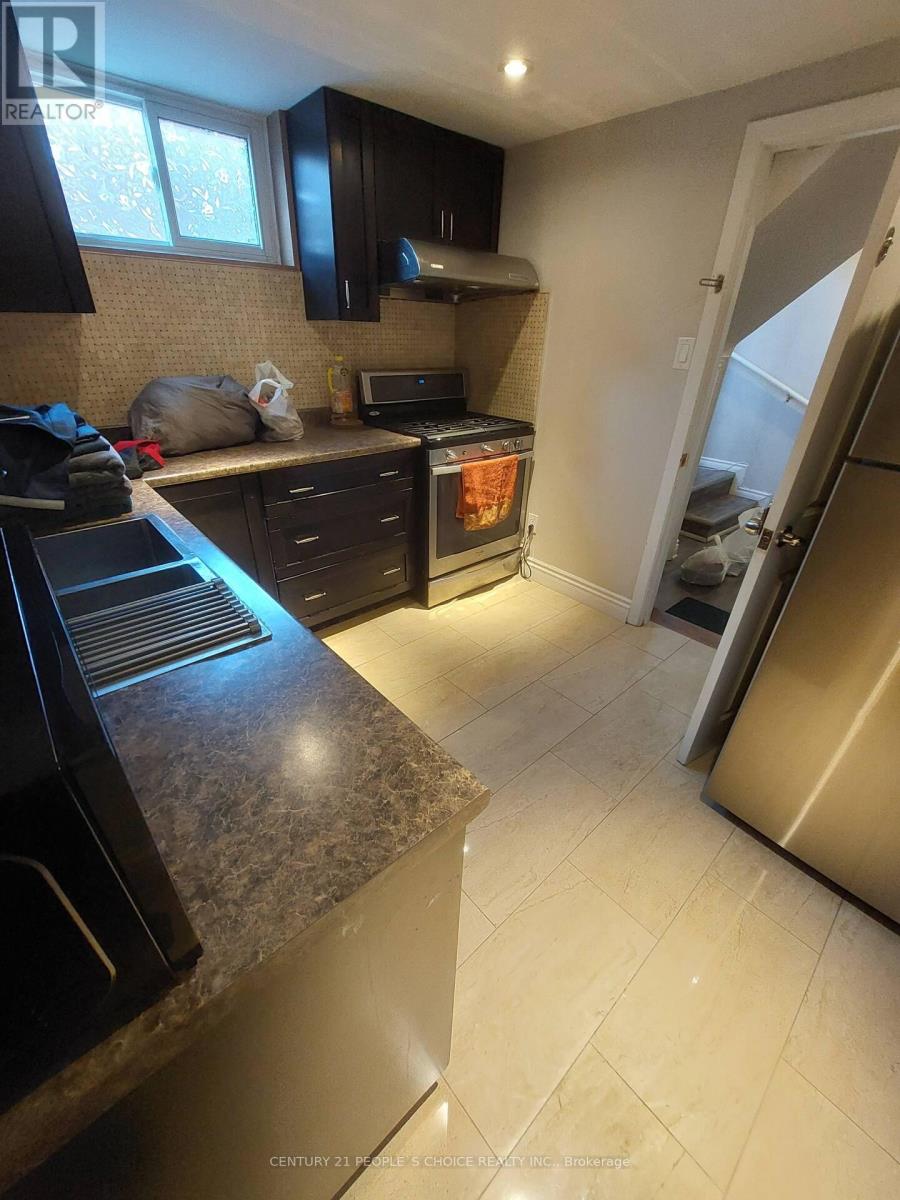 A kitchen with black cabinets and a granite countertop.