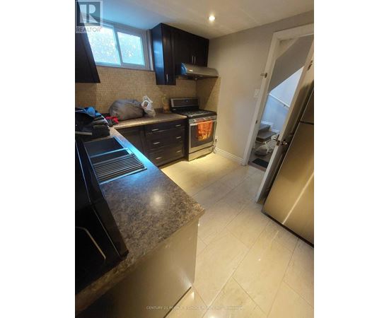A kitchen with black cabinets and a granite countertop.