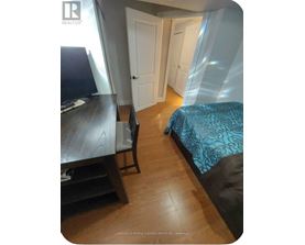 A bedroom with a bed, desk, and chair.