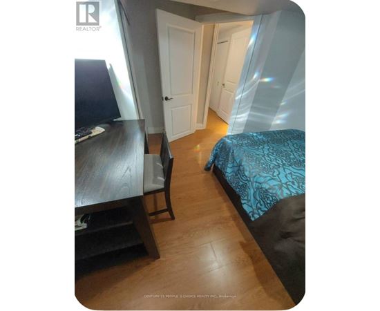 A bedroom with a bed, desk, and chair.