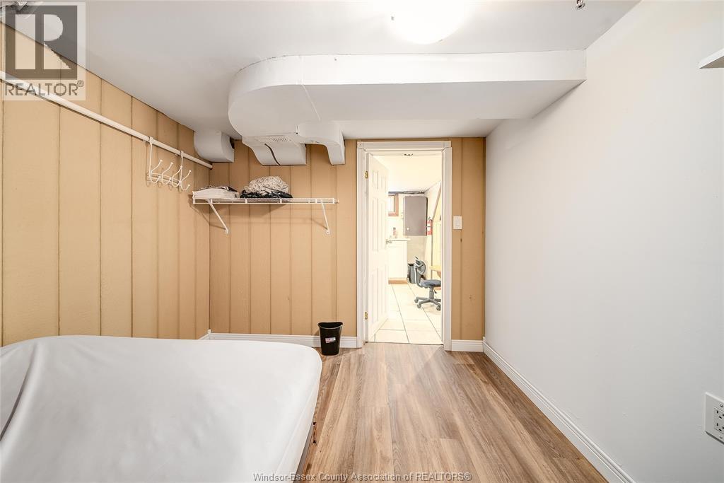 A bedroom with a bed on the left and a hallway on the right.
