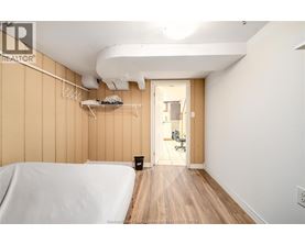 A bedroom with a bed on the left and a hallway on the right.